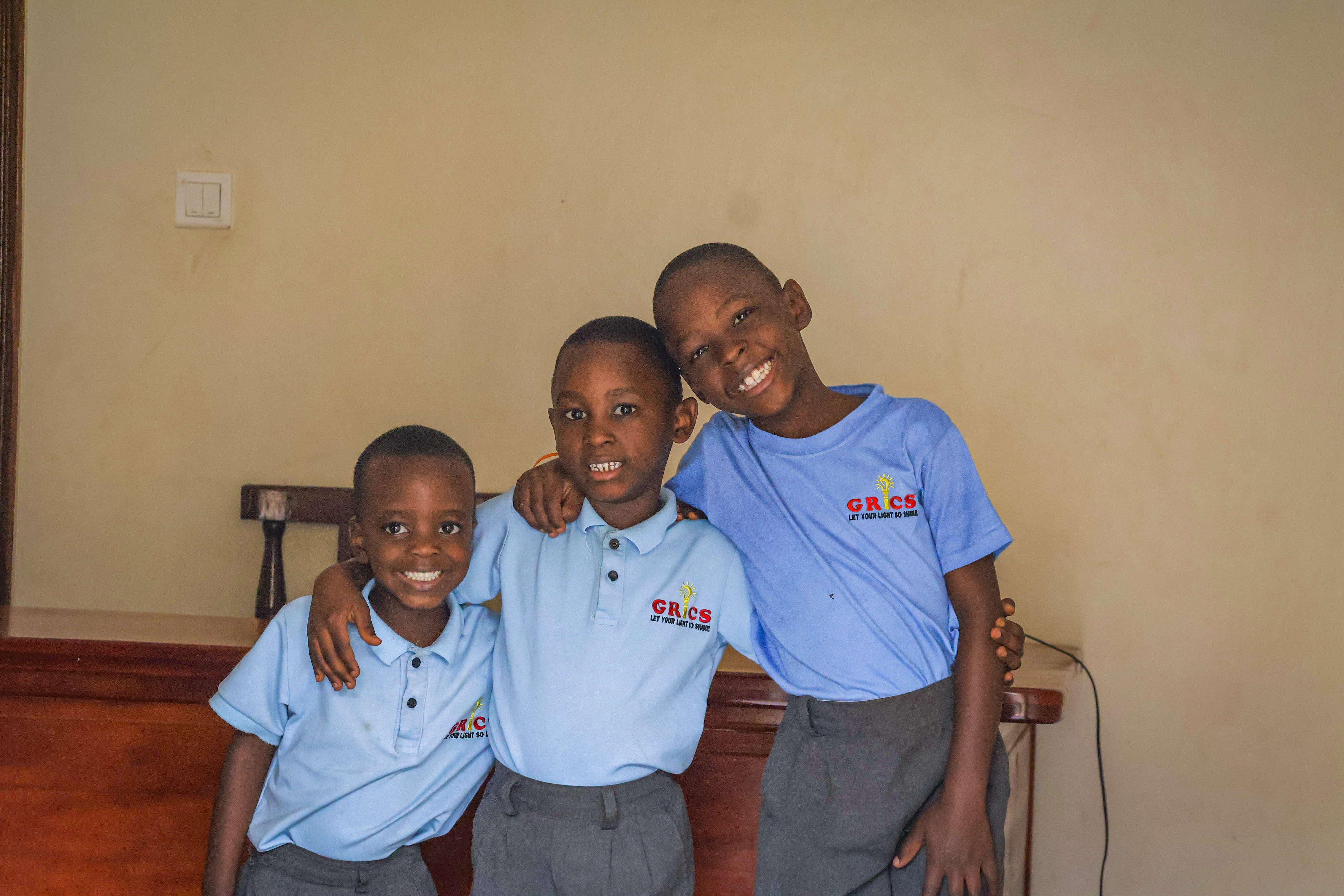 Three GRICS learners posing together with arms around each other